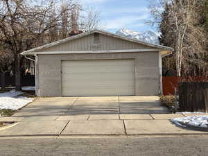 Snow covered garage featuring a garage and a mountain view