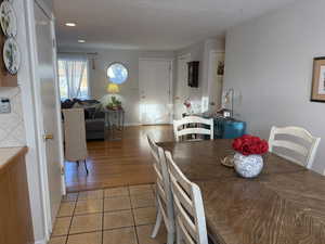 Dining room with light tile patterned floors and recessed lighting