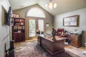 Office featuring a chandelier, lofted ceiling, light colored carpet, and french doors