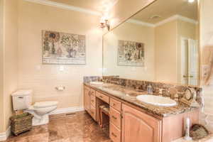 Bathroom with ornamental molding and double vanity