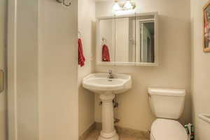 Half bath featuring toilet and tile patterned flooring