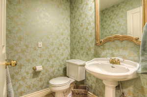 Bathroom with wallpapered walls and toilet