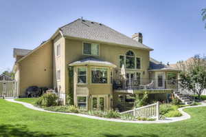 Back of property with stucco siding, a chimney, french doors, and roof with shingles