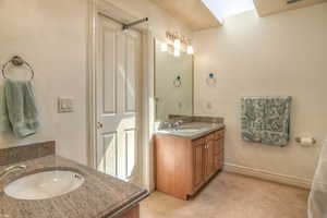 Bathroom with two vanities and light carpet