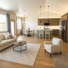 Living room with light wood finished floors, a chandelier, vaulted ceiling, and recessed lighting