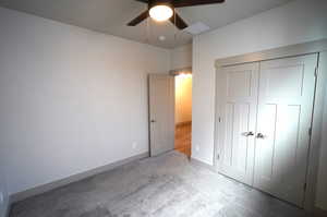 Unfurnished bedroom featuring carpet flooring, a closet, and ceiling fan