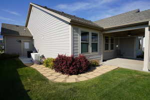 Back of property with roof with shingles, a yard, ceiling fan, and a patio