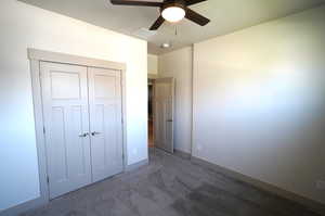 Unfurnished bedroom with carpet, a ceiling fan, and a closet