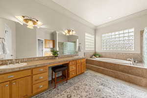 Full bathroom with double vanity, a shower stall, a bath, light tile patterned flooring, and crown molding
