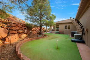 View of yard featuring an area to practice putting and a patio area