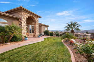 View of green lawn with a patio area and a mountain view