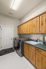 Laundry area with cabinet space, washer and clothes dryer, and a textured ceiling