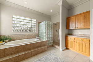 Full bathroom featuring a walk in shower, a bath, light tile patterned floors, vanity, and recessed lighting
