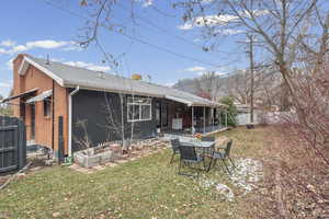 Rear view of house featuring a chimney, a patio, and a shingled roof