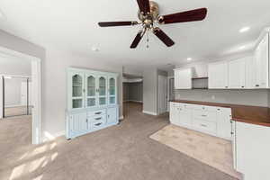 Kitchen featuring light colored carpet, ceiling fan, white cabinetry, recessed lighting, and open shelves