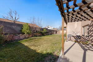 Fenced backyard with a pergola and a patio