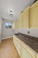 Kitchen featuring cream cabinets, dark countertops, and light wood finished floors
