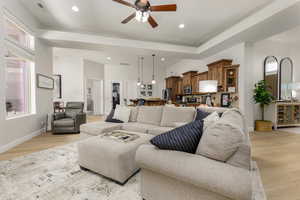 Living room featuring a ceiling fan, light wood-style floors, and recessed lighting