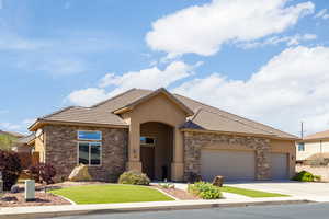 View of front of house featuring stone siding, stucco siding, and concrete driveway