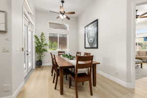 Dining room with ceiling fan and light wood-type flooring