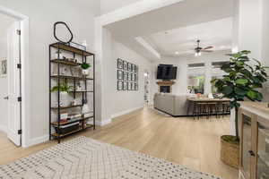 Living area with a fireplace, light wood-type flooring, recessed lighting, and a ceiling fan