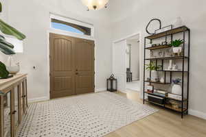 Entryway featuring light wood-type flooring and a high ceiling
