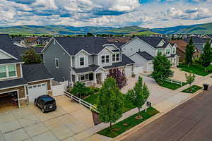 Traditional home with concrete driveway, a residential view, a mountain view, a garage, and roof with shingles