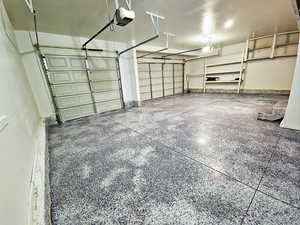 Garage featuring baseboards and a garage door opener