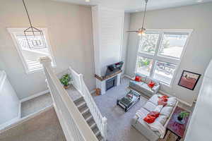 Carpeted living area featuring a towering ceiling, ceiling fan, and recessed lighting