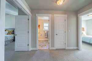 Hallway with a textured ceiling and carpet floors