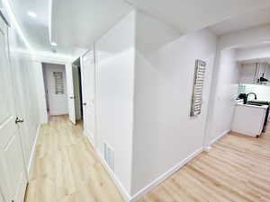 Corridor with light wood finished floors and recessed lighting