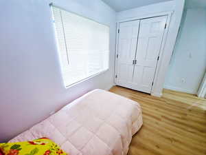 Bedroom with light wood-style floors and a closet