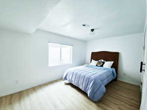 Bedroom with light wood finished floors and baseboards
