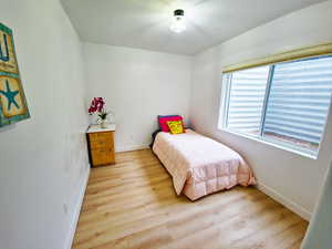 Bedroom with light wood-style floors and baseboards