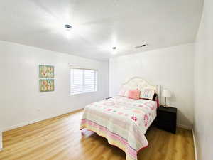 Bedroom featuring a textured ceiling and light wood-style flooring