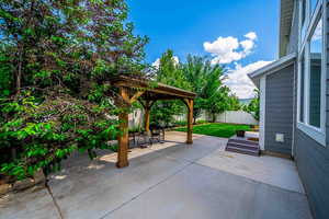 Fenced backyard featuring a gazebo and a patio area