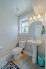 Half bath featuring a textured ceiling and light tile patterned flooring