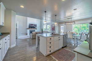 Kitchen with white cabinets, open floor plan, decorative light fixtures, a textured ceiling, and recessed lighting
