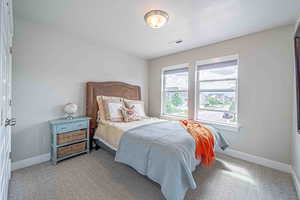 Carpeted bedroom featuring baseboards and a textured ceiling