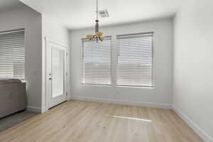 Unfurnished dining area with light wood finished floors and baseboards