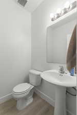 Half bath featuring baseboards and light wood finished floors