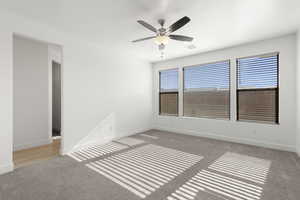 Unfurnished room with light colored carpet and a ceiling fan