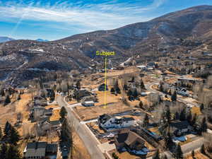 Aerial overview of property's location with a mountainous background and nearby suburban area