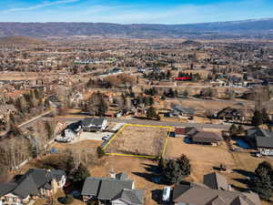Aerial view of residential area with property parcel outlined and mountains