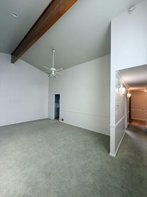 Unfurnished living room featuring carpet flooring and a ceiling fan