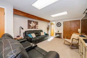 Carpeted living area with a glass covered fireplace