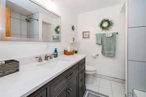 Bathroom with vanity, light tile patterned flooring, and a shower