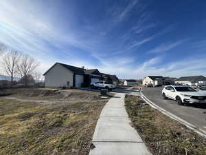 View of asphalt street with sidewalks, a residential view, and curbs