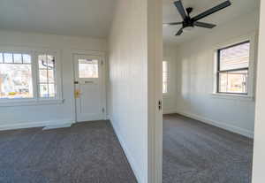 Foyer entrance with dark colored carpet, a textured wall, and crown molding