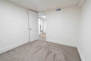 Carpeted spare room featuring baseboards